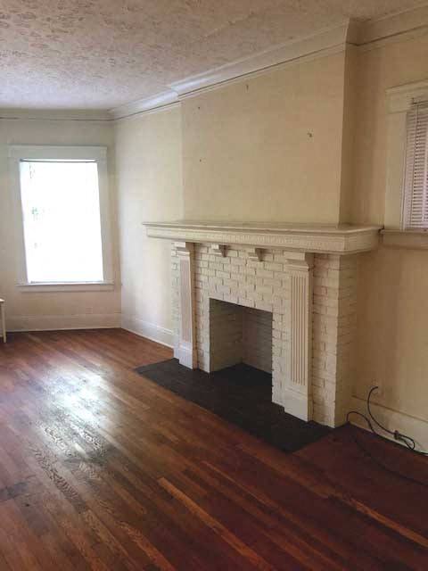 a living room with a fireplace and a wooden floor